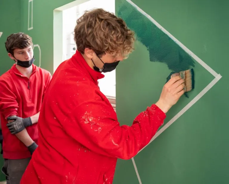 studente esegue la decorazione di un muro